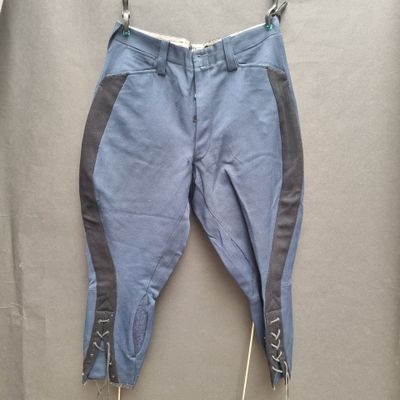 blue pants with zippers and zippers hanging on a hanger