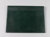 a black folder with a green cover on a white surface
