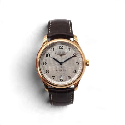 gros plan d'une montre sur une surface blanche avec un bracelet marron