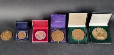 several gold medals are lined up in a row on a table