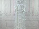 the wedding dress is on a mannequin stand in front of a wall