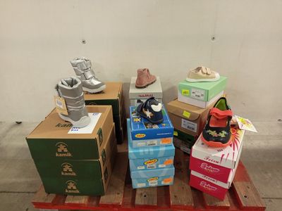 many boxes of shoes on a pallet in a room