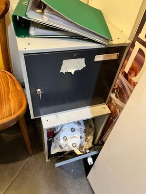 a stack of books sitting on top of a filing cabinet