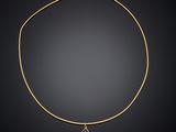 a gold necklace with a blue stone pendant on a black background