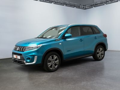 Le SUV bleu est garé dans une grande pièce aux murs blancs.
