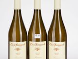 trois bouteilles de vin posées sur une table blanche