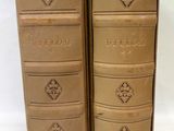 two old books sitting on top of each other on a white surface