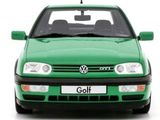 a green car that is parked on a white surface
