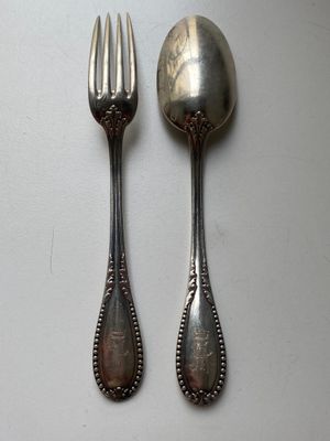 two spoons and a fork sitting on a table