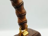 the handle of a brown bag with a wooden handle on a white surface