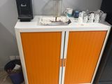 a small cabinet with a coffee maker on top of it