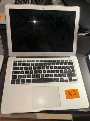 a laptop computer sitting on top of a desk next to a cell phone