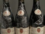 six bottles of wine are wrapped in plastic on a table