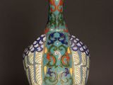 a vase on a wooden table with a black background
