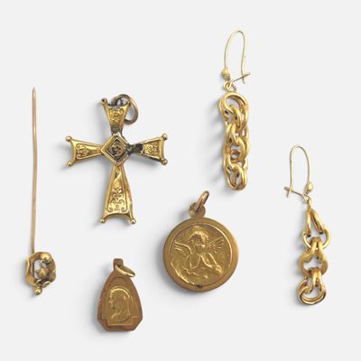 plusieurs bijoux en or, dont une croix, une médaille et une pièce de monnaie
