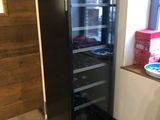 a black refrigerator in the corner of a room
