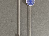 pair of silver and blue lapel pins on a gray surface