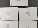 four white envelopes sitting on top of each other on a table
