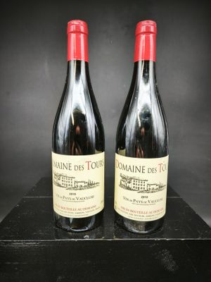 deux bouteilles de vin sont posées sur une table noire