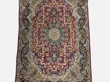 a red and blue rug with a medallion design on a white background