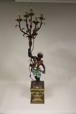 a figurine of a man holding a candelabra on a table