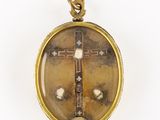 une image représentant un pendentif en forme de croix en or sur fond blanc
