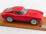 une maquette de voiture rouge posée sur un socle en bois