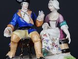 a figurine of a man and a woman sitting on a bench
