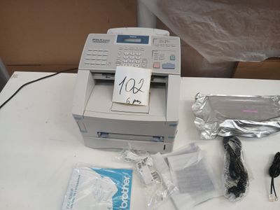 une photo représentant une imprimante et d'autres objets posés sur une table