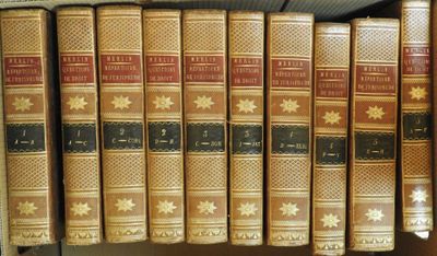 plusieurs vieux livres sont alignés sur une étagère dans une bibliothèque