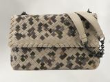 beige and black woven purse with chain strap on a white background