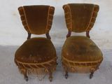 two chairs with fringes on them sitting next to each other