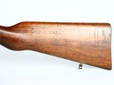 an old wooden rifle on a stand on a white surface