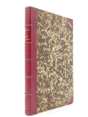 un vieux livre à la couverture rouge posé sur une surface blanche