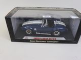 une petite voiture bleue dans une boîte posée sur une table