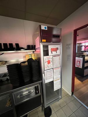 une petite cuisine avec un réfrigérateur et beaucoup de nourriture sur le plan de travail
