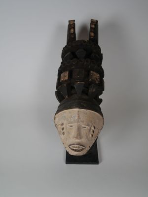 une image d'un masque en bois accroché au mur
