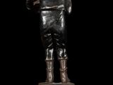 bronze statue of a man standing on a pedestal with his back to the camera