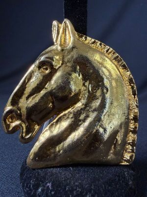 a gold horse head on top of a black stand