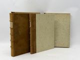 two old books sitting next to each other on a white surface