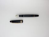 a pen and a ballpoint pen laying on top of each other