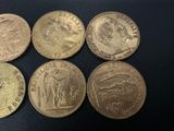 six different types of coins are shown on a black surface