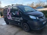 a black van parked in a parking lot with a pink ribbon on the side of it
