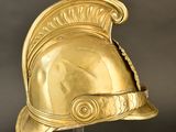 a gold helmet on a stand against a black background
