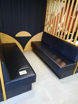 un canapé noir et un banc en bois dans une pièce