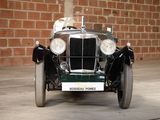 a vintage car that is parked in front of a brick wall