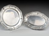 une paire de plats argentés posés sur des supports, sur une table