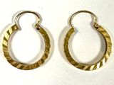 une paire de boucles d'oreilles créoles dorées sur fond blanc