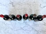 several bottles of wine are lined up on a marble surface