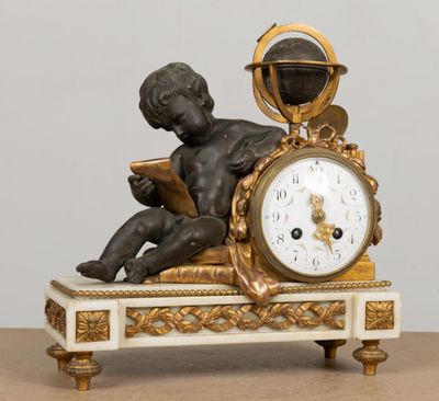 une statue représentant un garçon en train de lire un livre sur une horloge